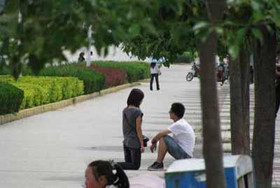 资料图：女大学生当街跪求男友谅解。