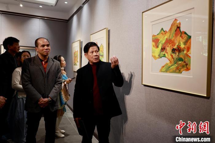 图为谭江宁(右)向访客介绍新瓷画作品。林馨 摄