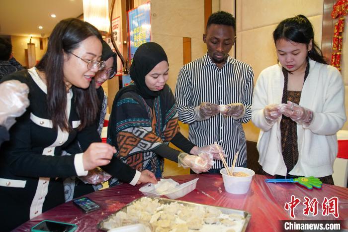 留学生们在老师指导下包饺子。陈冠言 摄