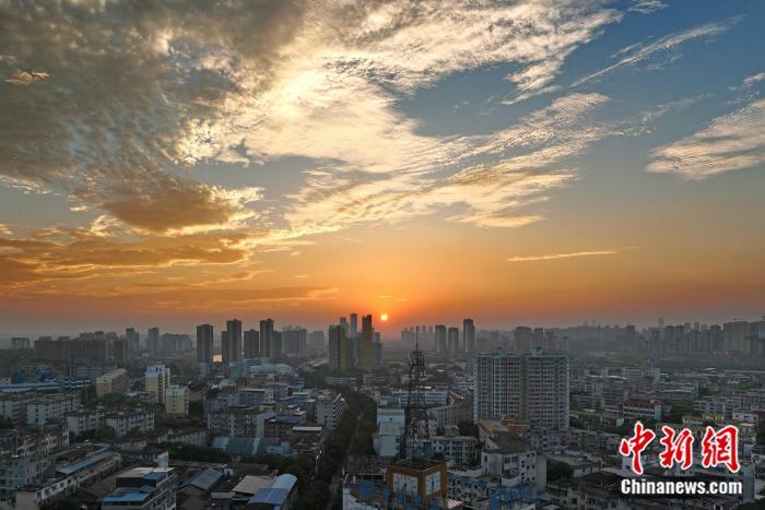 近日，广西南宁市邕宁区蒲庙镇红霞漫天，如鳞如絮。霞光与城市交相辉映，画面和谐静美。图为航拍晚霞映照下的南宁市。滕忠 摄