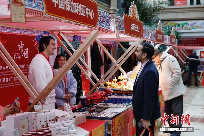 2月6日，“共享大市场 出口中国”北京国际精品荟——“汇全球 聚雅宝”欧亚国家精品推广周暨年货节于北京市朝阳区日坛国际贸易中心开幕。本次活动汇聚来自俄罗斯、伊朗、吉尔吉斯斯坦、摩尔多瓦、保加利亚、哈萨克斯坦等30多个欧亚国家地区的特色商品，为北京市民打造一站式国际年货采购平台。图为外国友人选购特色商品。   中新社记者 韩海丹 摄