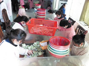 点钞员们在低头紧张地工作,她们每人每天都需要点钞25箱1万元以上。 陈暄 摄 点钞员们在低头紧张地工作,她们每人每天都需要点钞25箱1万元以上。 陈暄 摄