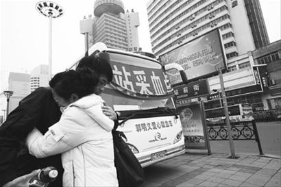 走出采血车,因献血认了姐弟的晓娜和周祥相拥告别。首席记者 李东 摄 走出采血车,因献血认了姐弟的晓娜和周祥相拥告别。首席记者 李东 摄
