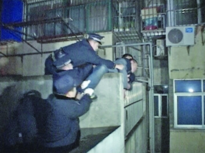 该男子正欲跳楼之际,被警方一把抱住 该男子正欲跳楼之际,被警方一把抱住