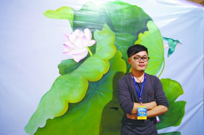 刘泽预在自己创作的手绘墙前。 万建辉 摄 刘泽预在自己创作的手绘墙前。 万建辉 摄