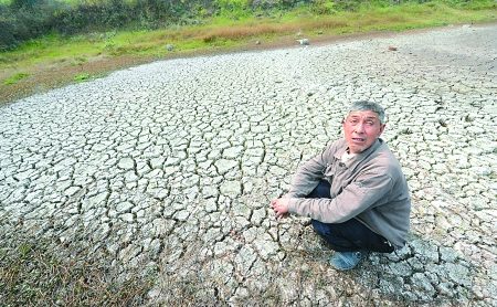 昨日,綦江区三江街道,村民罗建无奈地坐在干枯的水塘里。 本版图片由首席记者 钟志兵 摄 昨日,綦江区三江街道,村民罗建无奈地坐在干枯的水塘里。 本版图片由首席记者 钟志兵 摄