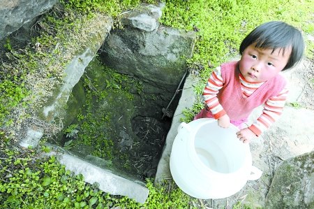 一个小女孩站在干枯的水井旁 一个小女孩站在干枯的水井旁