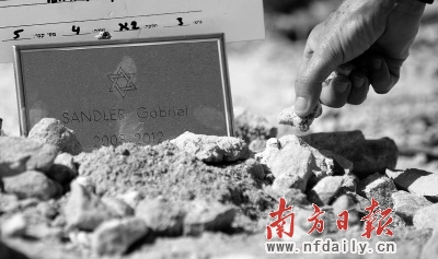 21日,4名枪击案遇难者在耶路撒冷安葬,数千犹太人参加了葬礼。一名妇女将一小块耶路撒冷石放在年仅4岁的遇难者坟墓上。新华社发 21日,4名枪击案遇难者在耶路撒冷安葬,数千犹太人参加了葬礼。一名妇女将一小块耶路撒冷石放在年仅4岁的遇难者坟墓上。新华社发