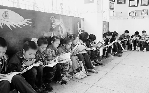 小学生们坐成一排在看书。本报资料图片 小学生们坐成一排在看书。本报资料图片