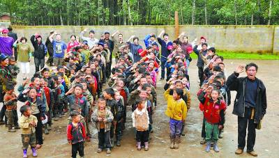 2010年7月,收古村,拉牛老师、孩子们和义工一起对国旗敬礼。现在,这些孩子全部失学。 2010年7月,收古村,拉牛老师、孩子们和义工一起对国旗敬礼。现在,这些孩子全部失学。
