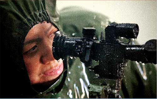 黄雪鹰在淋雨试验中对枪支瞄准镜进行调试 黄雪鹰在淋雨试验中对枪支瞄准镜进行调试