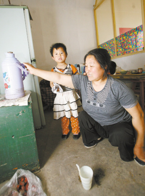 -苏平行动不便,仍和小孙女一起照顾邻居。记者 李志华 摄 -苏平行动不便,仍和小孙女一起照顾邻居。记者 李志华 摄