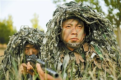 左图:张志坤(右)正在教士兵战场潜伏的射击技巧。石敬德摄 左图:张志坤(右)正在教士兵战场潜伏的射击技巧。石敬德摄