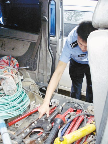 民警清点嫌疑人的作案工具。 记者王涛 通讯员许朝睿 摄 民警清点嫌疑人的作案工具。 记者王涛 通讯员许朝睿 摄