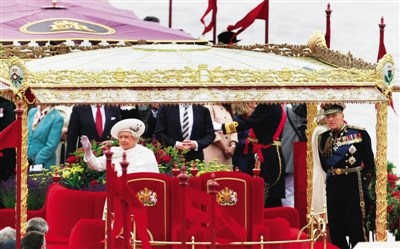 与民同欢 3日，女王登上王室游船后向民众招手