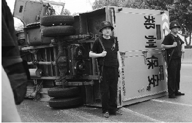 全副武装的押运员在车流中警惕地守在侧翻运钞车边。 全副武装的押运员在车流中警惕地守在侧翻运钞车边。