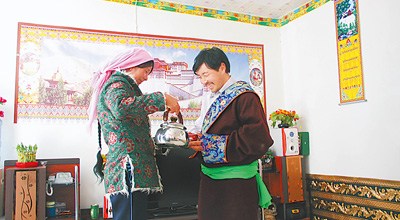 在沟里乡牧民定居点,达洛的妻子正向客人敬奶茶。记者 梁昌杰摄 在沟里乡牧民定居点,达洛的妻子正向客人敬奶茶。记者 梁昌杰摄