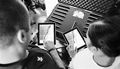 美国海军陆战队人员利用iPad查找地图。 美国海军陆战队人员利用iPad查找地图。