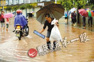 荣昌县吴家镇双流村街道变成泽国,一位村民在水中捞出车牌。 重庆晚报首席记者 冉文 摄 荣昌县吴家镇双流村街道变成泽国,一位村民在水中捞出车牌。 重庆晚报首席记者 冉文 摄