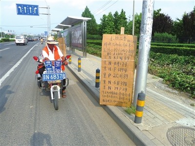 老姚一直在捡拾车牌的地段守候并寻找失主。本报记者周琦摄 老姚一直在捡拾车牌的地段守候并寻找失主。本报记者周琦摄