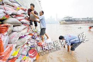 抢险人员正用沙袋堵洪水,确保南滨路音乐喷泉主控室安全。 抢险人员正用沙袋堵洪水,确保南滨路音乐喷泉主控室安全。