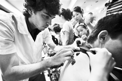 2010年7月19日，杭州，澳大利亚籍留学生安德雷在为市民进行“冬病夏治”诊疗