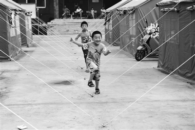 孩子们在临时安置点玩耍。新京报记者 尹亚飞 摄