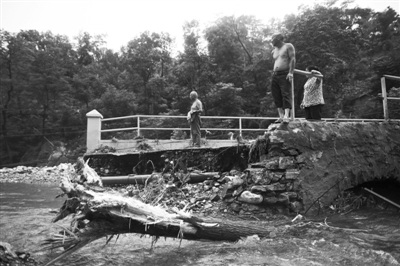 昨日，房山圣水峪村，村民在一冲毁的桥上观看灾情。“7・21”暴雨后，这里曾一度变成“孤岛”