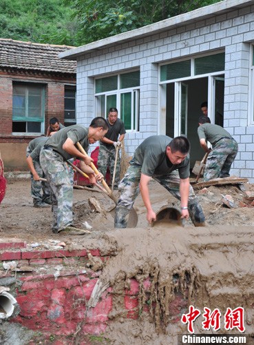 官兵挨家挨户清理淤泥。 <a target='_blank' href='http://www.chinanews.com/' >中新网</a> 陈海峰摄 官兵挨家挨户清理淤泥。 <a target='_blank' href='http://www.chinanews.com/' >中新网</a> 陈海峰摄