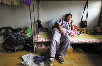 7月31日,京港澳高速旁河西再生水厂建筑工地,李川南躺在床上打电话。床下,放着慰问者送来的水果。本版摄影/新京报记者 薛珺 7月31日,京港澳高速旁河西再生水厂建筑工地,李川南躺在床上打电话。床下,放着慰问者送来的水果。本版摄影/新京报记者 薛珺