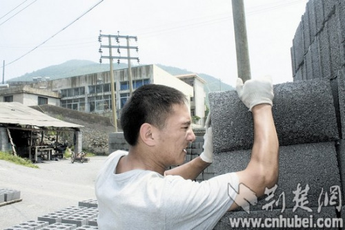 图为:张虎成在砖瓦厂里搬砖 图为:张虎成在砖瓦厂里搬砖