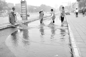 大雨过后,环卫工人正在清理路面积水。 本报记者 贾宁 摄 大雨过后,环卫工人正在清理路面积水。 本报记者 贾宁 摄