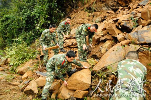 官兵齐心协力搬运石块抢通受阻路段。图片来源:人民武警报 官兵齐心协力搬运石块抢通受阻路段。图片来源:人民武警报