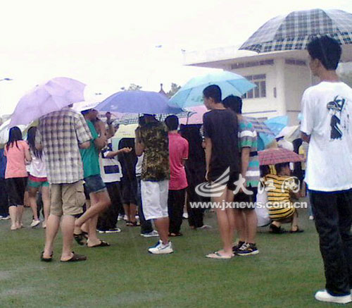 学生打伞雨中站立。(网友供图) 学生打伞雨中站立。(网友供图)