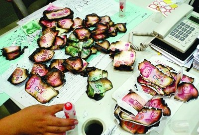 银行工作人员清点粘贴残缺人民币 银行工作人员清点粘贴残缺人民币