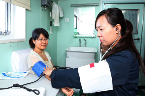 停靠牙买加期间,随舰医疗组为我驻牙买加大使馆工作人员及其家属进行了体检等医疗服务。图为乔湘婷在为使馆人员家属测血压。王平 摄 停靠牙买加期间,随舰医疗组为我驻牙买加大使馆工作人员及其家属进行了体检等医疗服务。图为乔湘婷在为使馆人员家属测血压。王平 摄