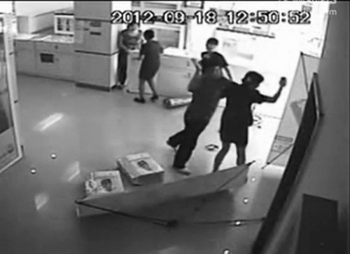 网络视频截图中,一男子追打一名女营业员 网络视频截图中,一男子追打一名女营业员