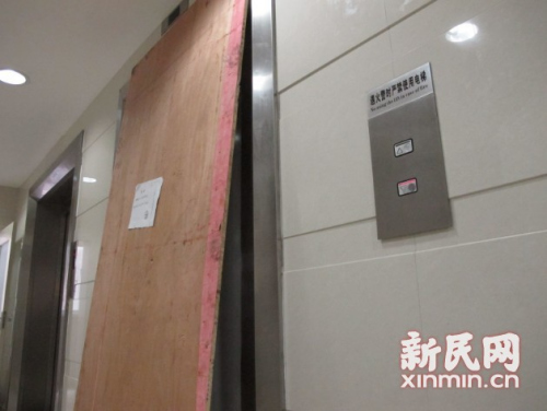 图说:电梯门被一块木板挡住。新民网记者 沈文林 现场回传 图说:电梯门被一块木板挡住。新民网记者 沈文林 现场回传
