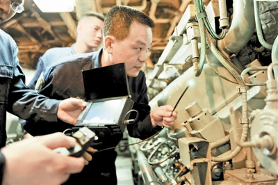 技术人员运用视频型内窥镜检查发动机气缸。 周亚文摄 技术人员运用视频型内窥镜检查发动机气缸。 周亚文摄