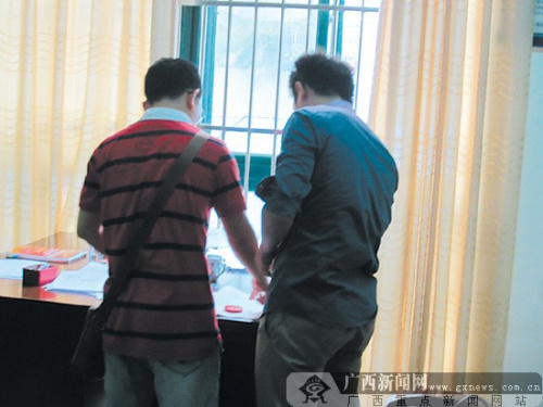 民警正在给王杰(左)办理领回电脑手续 民警正在给王杰(左)办理领回电脑手续