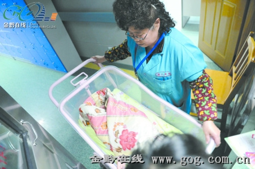 贵阳市妇幼保健院工作人员将女婴送进体检室。 贵阳市妇幼保健院工作人员将女婴送进体检室。