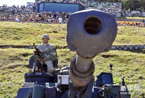 　　资料图片：9月30日，在韩国抱川的一个军事训练基地，一名美国士兵坐在榴弹炮上参加韩美联合军演。