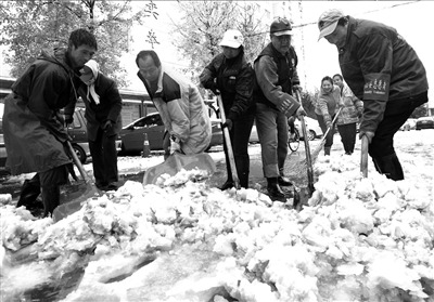 志愿者们在路上扫雪铲冰。记者范继文摄 志愿者们在路上扫雪铲冰。记者范继文摄