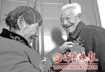 王翠兰老人为老伴戴上胸花。 王翠兰老人为老伴戴上胸花。