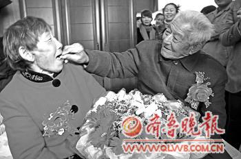 张继友老人喂老伴吃下喜糖。 张继友老人喂老伴吃下喜糖。