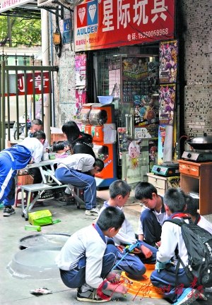 小朋友在小店门前玩陀螺。 实习生黄攀 记者杨勤 摄 小朋友在小店门前玩陀螺。 实习生黄攀 记者杨勤 摄