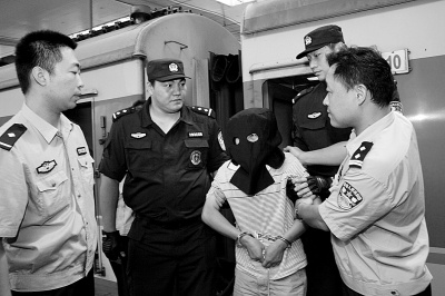 嫌疑人曾某被押解回汉。 嫌疑人曾某被押解回汉。