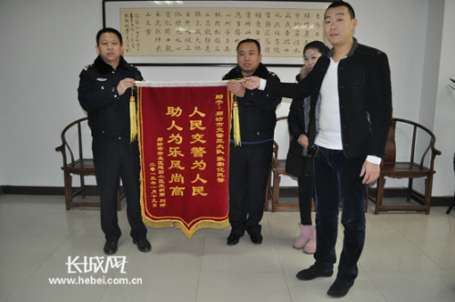 患儿父母向廊坊开发区交警赠送锦旗。长城网 刘振山 摄 患儿父母向廊坊开发区交警赠送锦旗。长城网 刘振山 摄