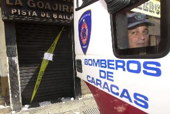 12月1日,一名消防队员站在委内瑞拉首都加拉加斯市中心一失火的迪斯科舞厅外。(资料图) 12月1日,一名消防队员站在委内瑞拉首都加拉加斯市中心一失火的迪斯科舞厅外。(资料图)