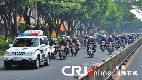 梅州锭子桥前面国道封路,当地交警为返乡摩托车流带路绕行。何志林 摄 梅州锭子桥前面国道封路,当地交警为返乡摩托车流带路绕行。何志林 摄
